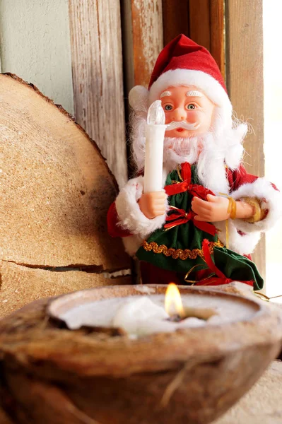 Santa Claus and a candle in a coconut — Stock Photo, Image