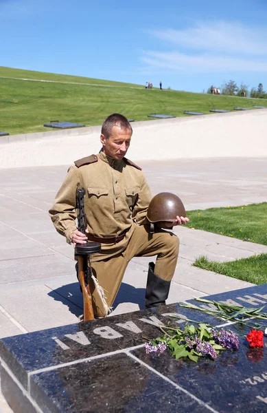 Fighter of Red Army bent a knee at a gravestone with an inscript — Stock Photo, Image