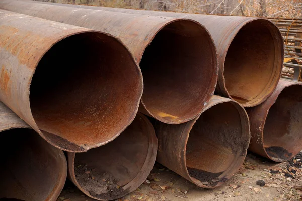 Big rusty pipes on construction object