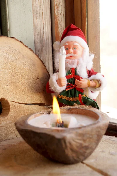 Santa Claus and a candle in a coconut — Stock Photo, Image