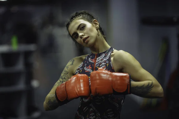 Caucasian Tattooed female athlete Muay Thai in boxing gloves  se