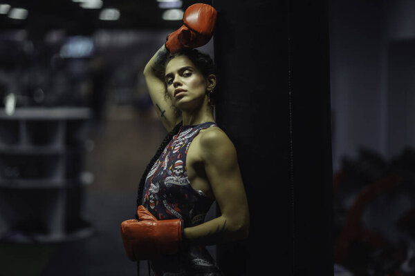 beautiful tattooed Caucasian girl boxer in sports clothing. Musc