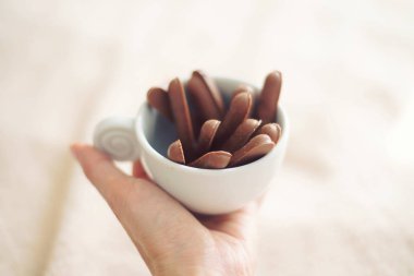 bir fincan çay veya kahve için lezzetli Çikolata Bisküvi sabah tutan el