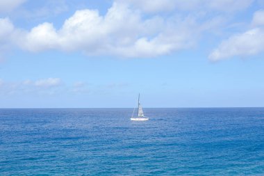 beyaz büyük kabarık bulutlar ve denizde bir tekne ile mavi gökyüzü arka plan 