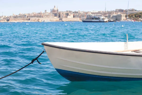 A small  boat in the sea with an amazing panoramic view of an ancient capital city Valletta in Malta on background — Stock Photo, Image