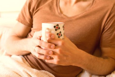 sabah uyanma sonra erken yatakta çay tutan genç bir adamın elleri closeup