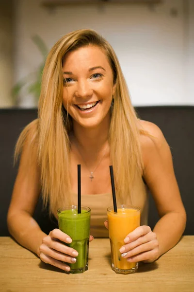 Beautiful smiling  young girl in a health cafe drinking smoothies. Go vegetarians. Healthy life  with nature products.