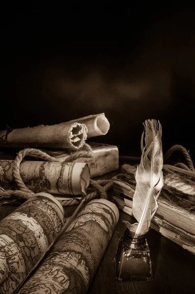 Quill pen, inkwell and old rolled up maps and papers, sepia effect