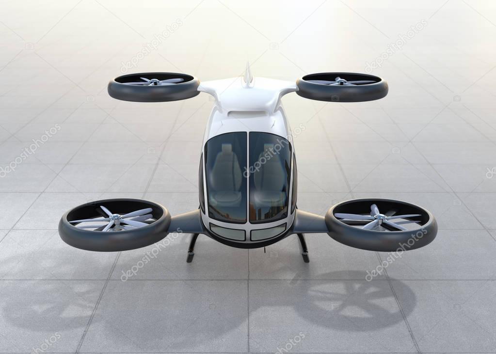 Front view of white self-driving passenger drone landing on the ground