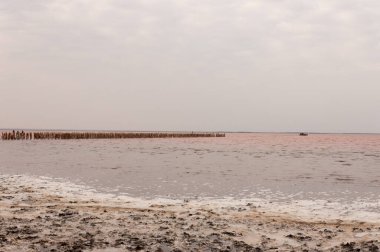 Pembe bir göl üzerinde terk edilmiş bir tuz madeni manzarası.