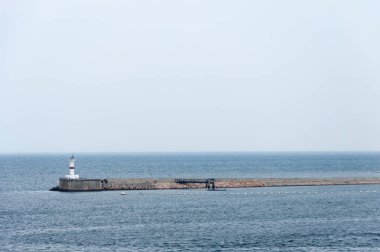 Açık alanların arasında yalnız duran deniz feneri.