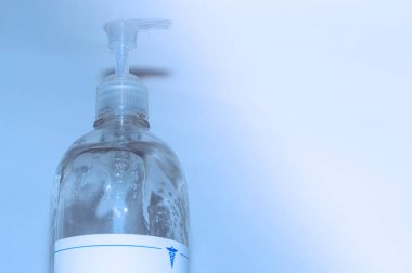 Covid19 Coronavirus gibi virüslerin yol açtığı hastalıkları önlemek için önlem olarak antibakteriyel jel kullanan eller. Bogota Kolombiya 'da ışık ve mavi arka planda el temizliği. Botella de Jabn antibakteriyel para la limpieza de las manos.