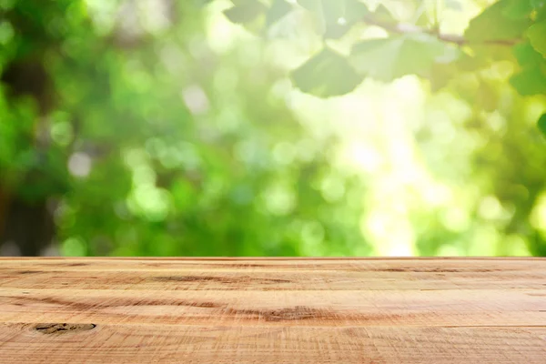 Mesa de madeira e borrão verde floresta fundo . — Fotografia de Stock