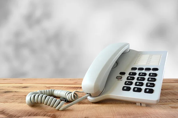 Weißes Telefon auf Holz. — Stockfoto