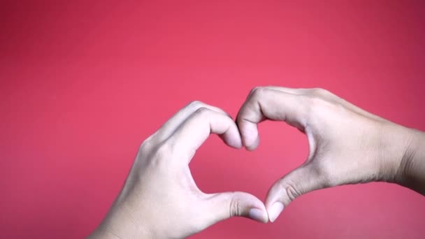 Zoom dans les mains faisant forme de coeur sur fond rouge . 