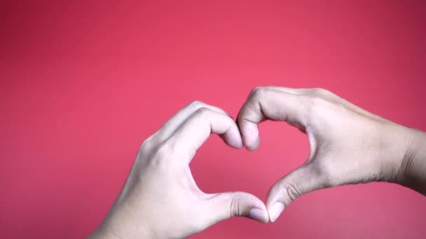 Zoom Las Manos Haciendo Forma Corazón Sobre Fondo Rojo — Vídeos de Stock