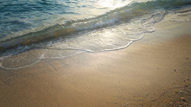 Tropikal denizde gün batımı ve denizin yumuşak dalgası, yaz sahili arka planı.