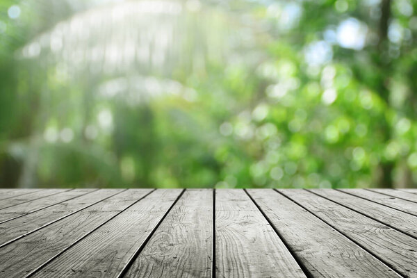 Wooden desk and blurred nature bokeh background.