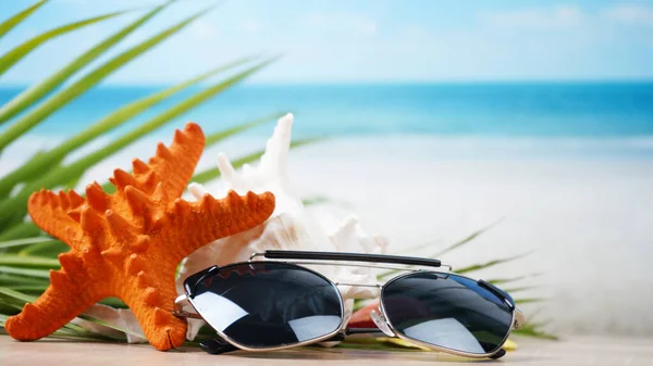 Sonnenbrille Mit Muscheln Und Verschwommenem Strandhintergrund — Stockfoto