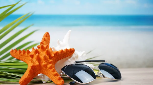 Sonnenbrille Mit Muscheln Und Verschwommenem Strandhintergrund — Stockfoto