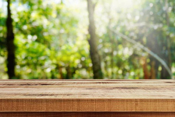 Ahşap masa ve bulanık bahçe doğa arka planı..