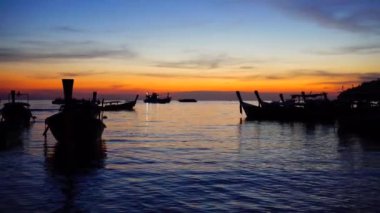 Denizde gün batımı güzel doğa manzarası arka plan ve siluet yelkenli tekneler.