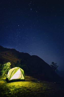 yaz mevsiminde yumuşak odaklı yıldız geçmişiyle dağdaki renkli kamp çadırından macera yolculuğu