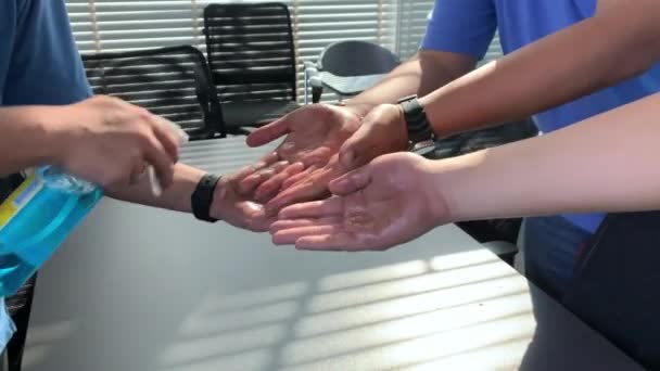 オフィスの従業員に広がるCovid 19ウイルスを保護するための清潔な手にアルコールを適用します — ストック動画