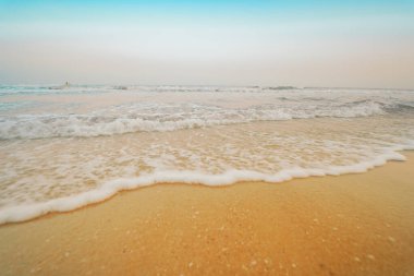 Yaz mevsimi seyahati kumsaldan dalgalı ve mavi gökyüzü arka planlı