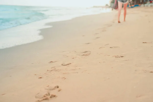 foot print on sand beach with soft focus beach background on summer season