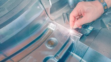 Teknisyenlerin elleri, mekanik enjeksiyon kalıpları fabrikasında ölçüm için ekipman kullanır.