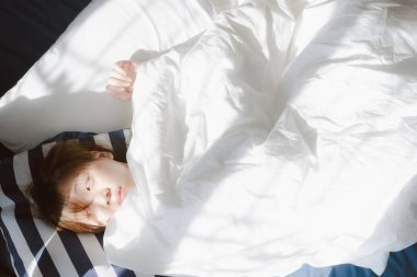 Üst tabaka güzel Asyalı kadın işten sonra evinde rahat rahat uyuyor.