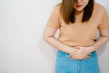 Beyaz izole edilmiş portre karın ağrısı ve karın ağrısı. 30-40 yaşlarındaki kadınların acı hissi. Pastel renkte, fotokopi alanı olan kumaşlar.