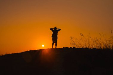 İnternet afişi ve macera gezisi siluet adam yürüyüş ve yaz mevsiminde dağın tepesinde durmak