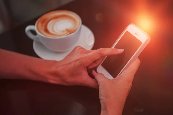 Femme prenant un café et utilisant son téléphone — Photo