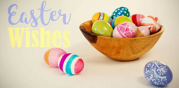 Colorful easter eggs in wooden bowl — Stock Photo, Image