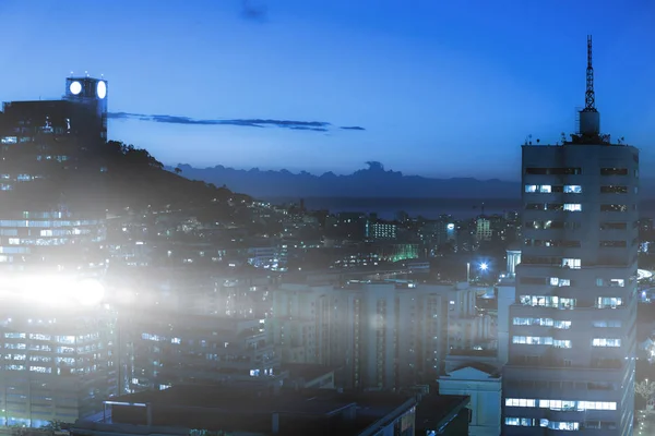 Освітлені будівлі в місті проти неба — стокове фото