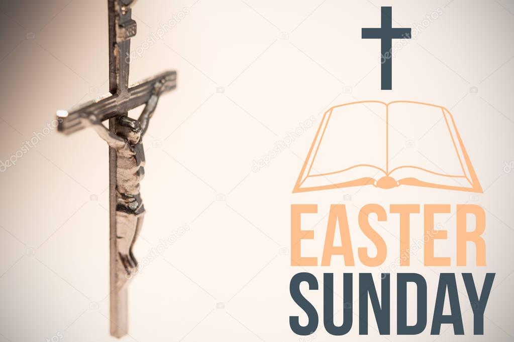 Easter sunday logo against close up of silver crucifix