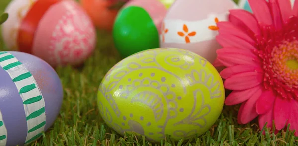 Easter eggs with pink flower on grass — Stock Photo, Image