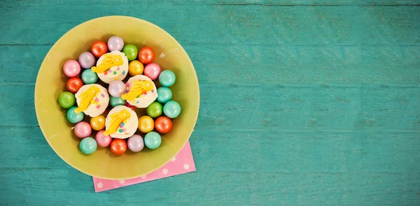 Chocolats colorés et cupcakes dans un bol — Photo