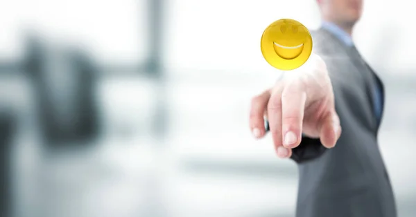 Homem de negócios apontando emoji com flare contra embaçado escritório cinzento — Fotografia de Stock