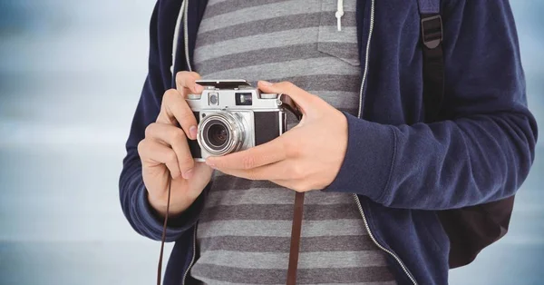 Man met de camera midden sectie tegen wazig blauwe houten paneel — Stockfoto