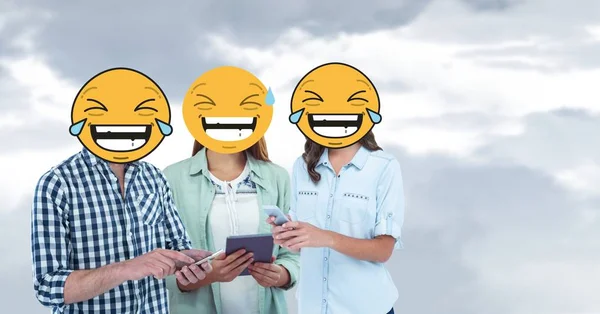 Amigos com rindo emojis usando telefones inteligentes — Fotografia de Stock
