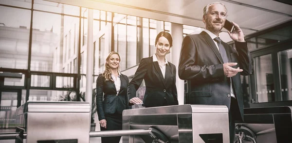 Businesspeople scanning cards at turnstile gate — Stock Photo, Image