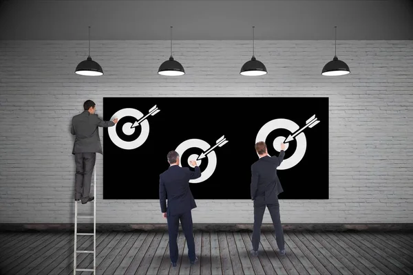 Hombres de negocios fijando objetivos en la pared — Foto de Stock