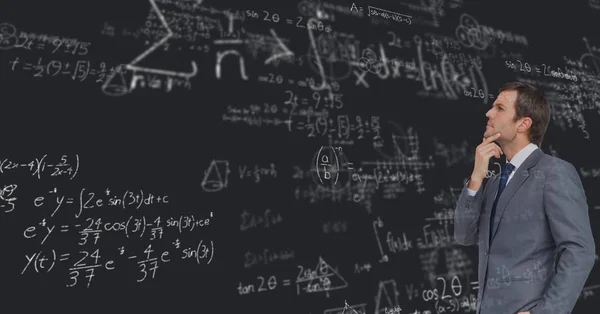 Empresário, olhando para as equações no quadro-negro — Fotografia de Stock