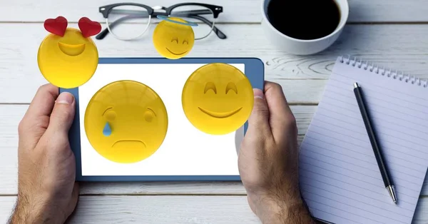 Mãos segurando o tablet digital com emojis saindo — Fotografia de Stock