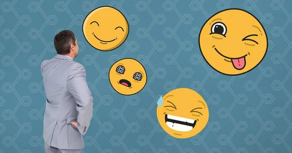 Empresario mirando varios emojis — Foto de Stock