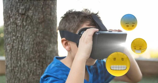 Хлопчик дивиться на Emojis через VR окуляри — стокове фото