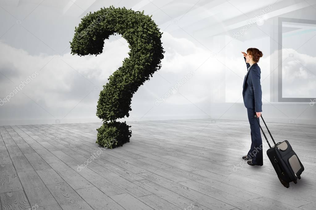 Businesswoman with bag looking at question mark made of plants